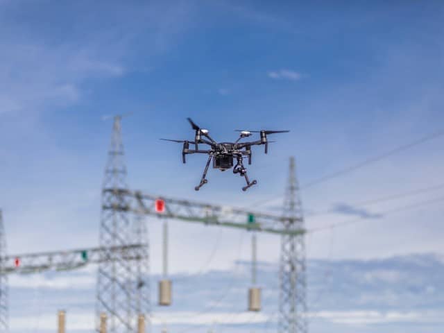 Industriedrohne vor einem Strommast - Drohnenaufnahmen